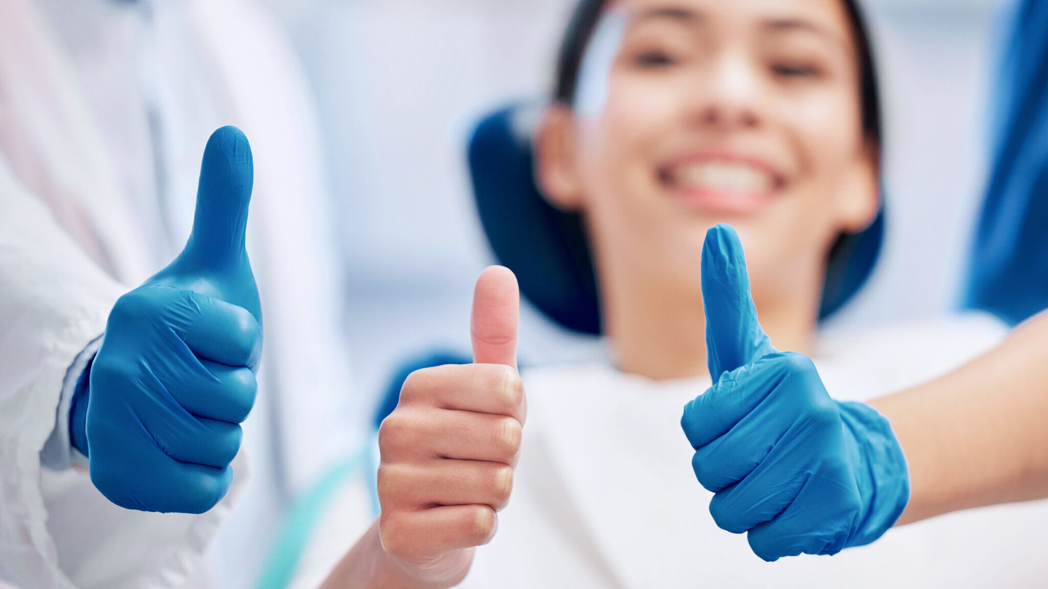 Shot of a young woman giving the thumbs up with her dentist